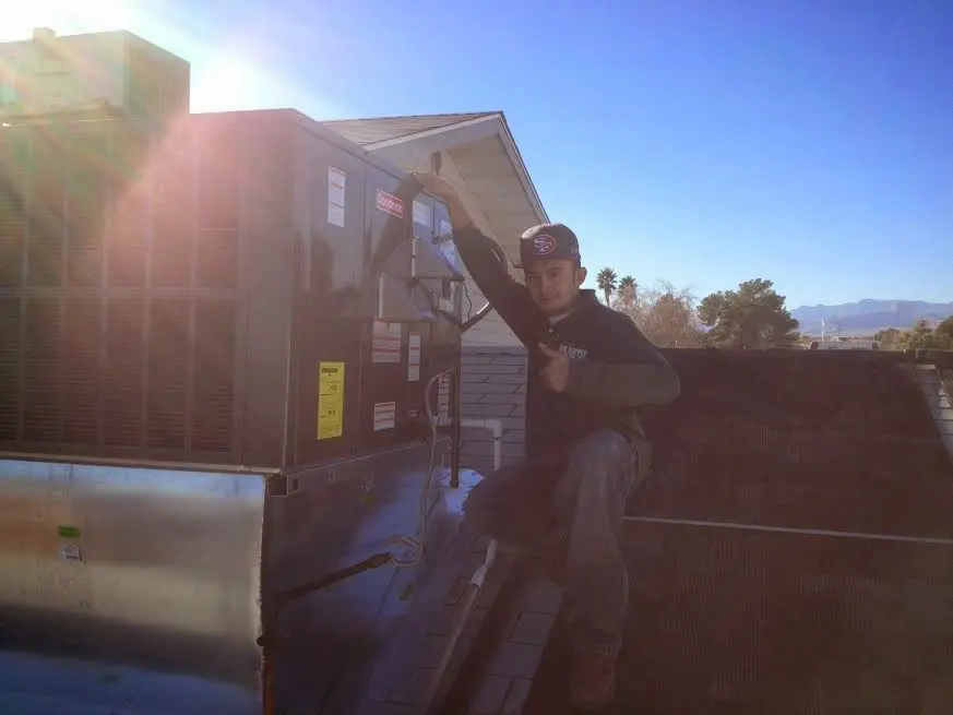 HVAC technician performing HVAC Inspection on a rooftop unit in Mattapoisett